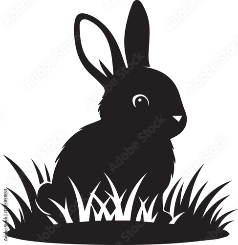 Charming silhouette of a black rabbit sitting in tall grass spring meadow