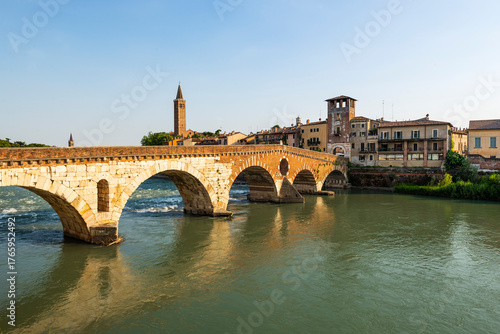 Die römische Ponte Pietra über dem Fluß Etsch in der Altstadt von Verona leuchtet in der Abendsonne, Venetien, Italien