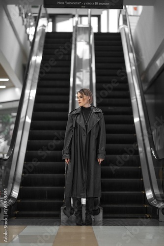 Wallpaper Mural Woman in a long coat standing in front of an escalator in a shopping mall Torontodigital.ca