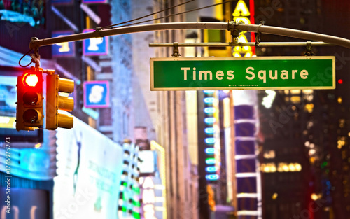 Times Square sign and red stop light in New York City at night