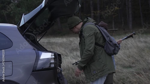 Couple unpacking car trunk for hiking trip in nature