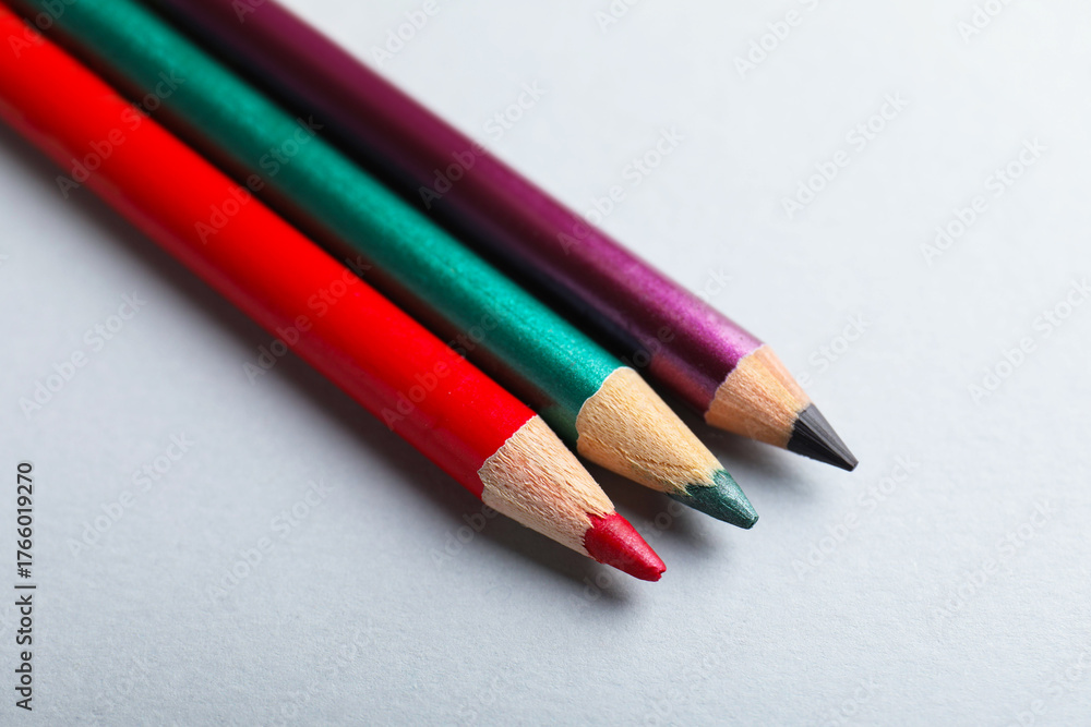 Fototapeta premium Colorful eye pencils on light background, closeup