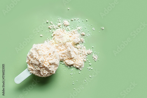 Scoop of whey protein powder on green