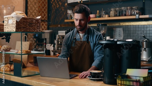 Canvastavla Pensive Caucasian staff employee restaurant worker barista guy using laptop orde