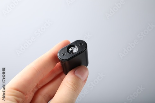 Wallpaper Mural Woman holding modern hidden spy camera on light grey background, closeup Torontodigital.ca