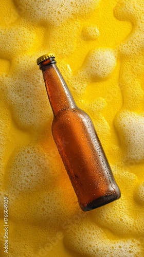 Brown Beer Bottle With Droplets on Yellow Foam Background in Bright Light