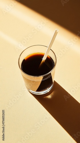 Morning Coffee in a Glass With a White Straw on a Light Surface and Sun Rays ...
