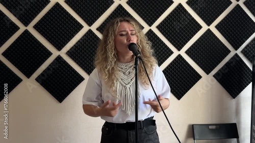Caucasian woman singing into microphone in music studio. 