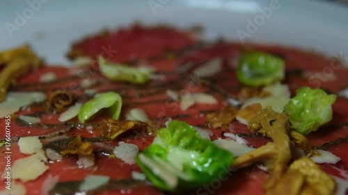 Authentic italian beef carpaccio decorated with parmesan and chanterelles gourmet appetizer fine dining cuisine close up elegant restaurant serving traditional delicacy stylish plate culinary.