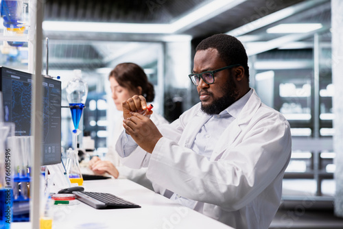 Εκτύπωση καμβά Chemical engineer in lab inspecting chemical compound clarity in vials for purity verification