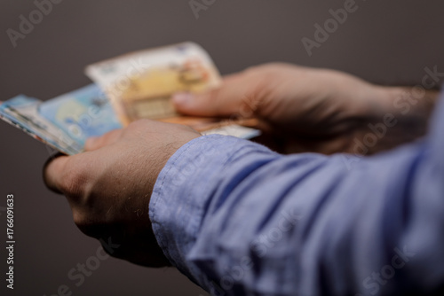 Man's hands holding Euro ba...