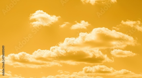 A stunning, saturated yellow sky filled with fluffy white cumulus clouds floating gently across the vast, warm expanse. Peaceful summer backdrop ,summer ,intense ,cheerful