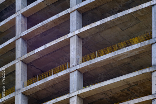 The repeating pattern of floors and columns in an unfinished multi story concrete building structure under construction