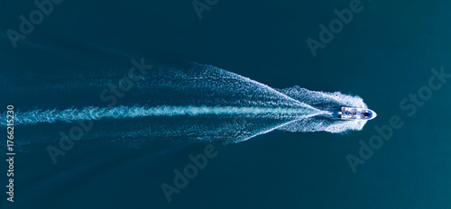 Foto Detailed top-down aerial view of a motorboat with people speeding across dark blue open water
