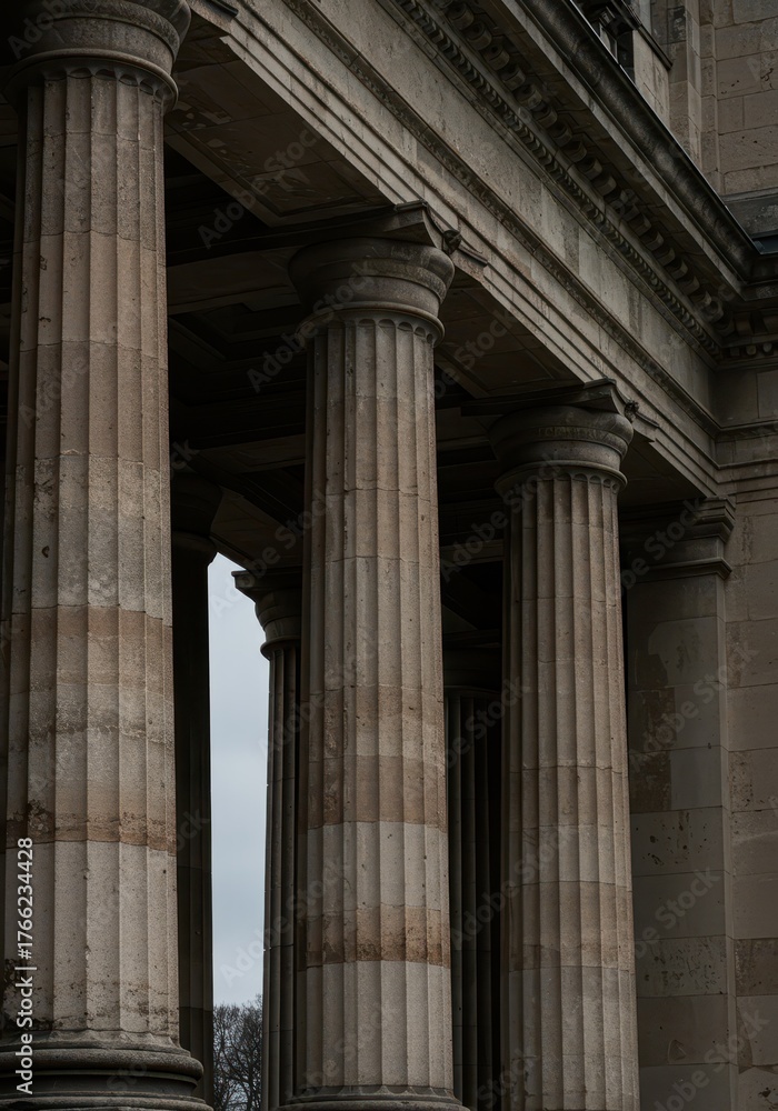 Naklejka premium Tall, fluted stone columns supporting a massive stone architrave. Classical architecture detail displaying age, strength, and durability ,column ,detail ,aged