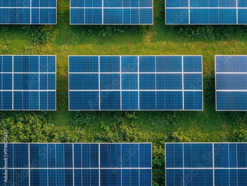 Aerial view of solar panels on a green field for renewable energy production.