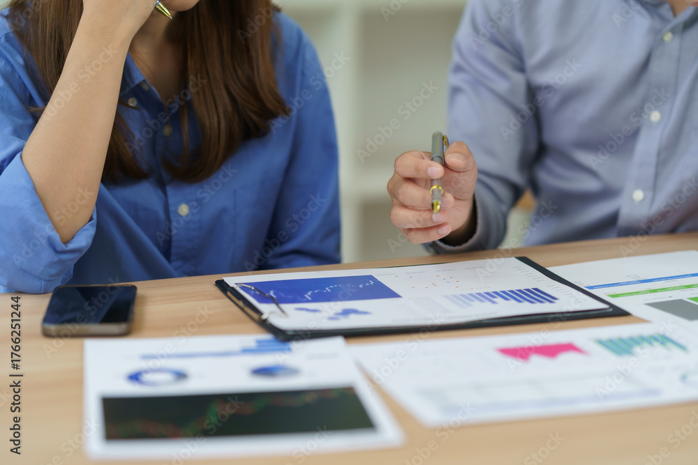 Obraz premium Businesspeople discussing financial charts and graphs during a meeting, analyzing market data for planning and strategy