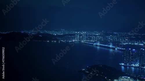 Busan Marine City and Gwangandaegyo Bridge glowing blue at night, facing the tranquil sea