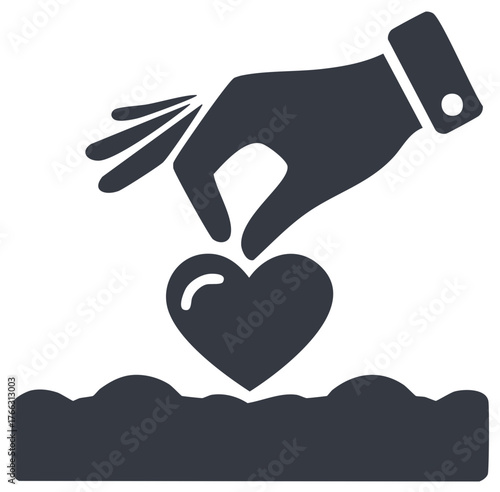 Hand planting a heart seed into the soil symbol for growth, charity, and new beginnings