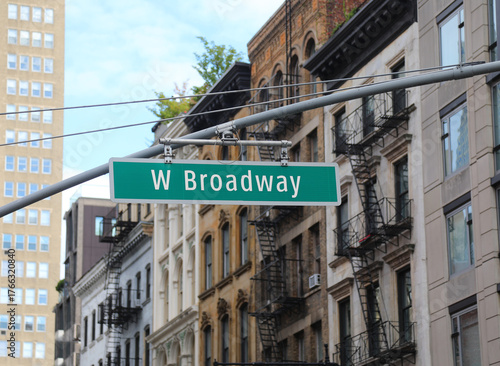 road sign hanging in the middle of a new york intersection with text W Broadway