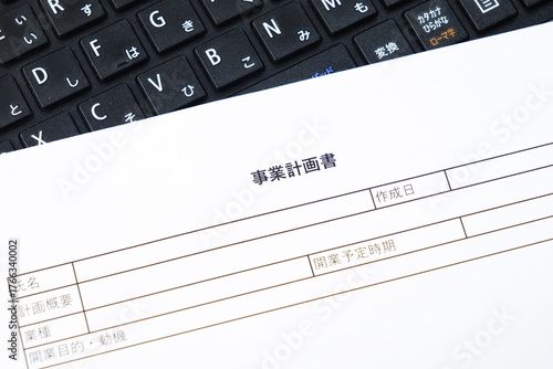 事業計画書 - 新規事業の立ち上げに先立ち、事業計画書を作成する起業家のイメージ
