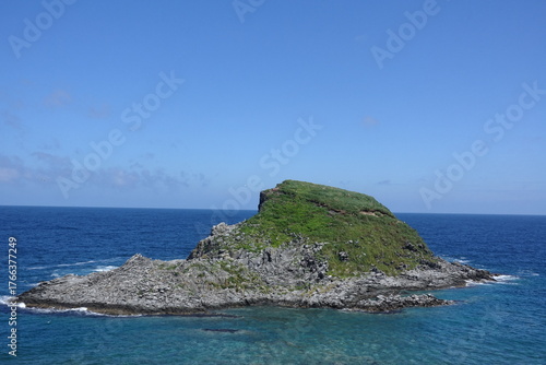 Fototapeta Rocky islet with grassy crown in clear blue Sea of Japan off Rishiri Island, Hok