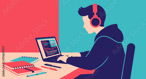 Young man with headphones programming on a laptop at his desk.