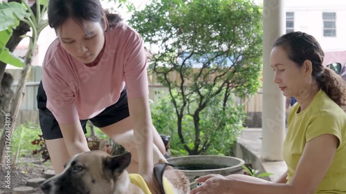 Mother and daughter drying their dog's fur after bathing.