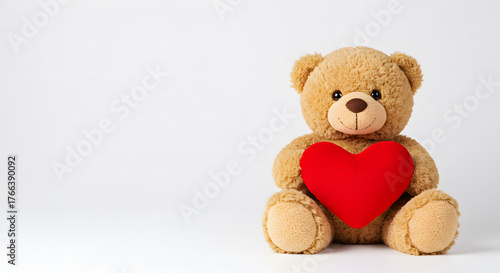 Light brown teddy bear  holding a red heart isolated on white background. Valentine's Day.
