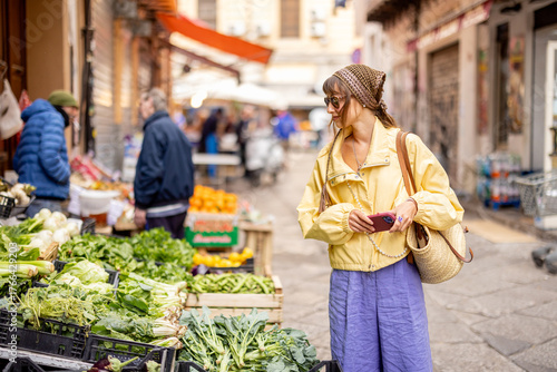 Foto Woman browsing fresh vegetables at a traditional Sicilian street market in Palermo