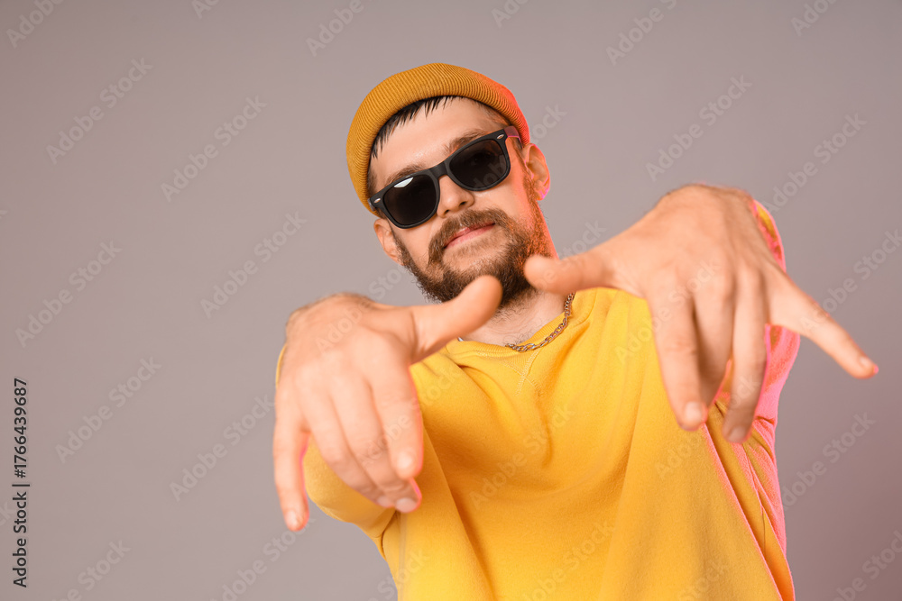 Naklejka premium Handsome male hip-hop dancer on grey background