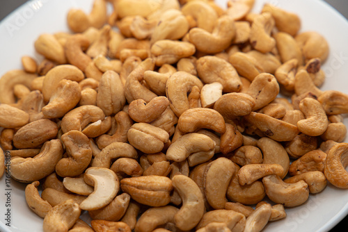 Cashews on a plate, top view. Loose cashews, close-up. Healthy eating concept.