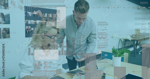 Photos Pointing at charts, professionals in office attire collaborating at desk, with l