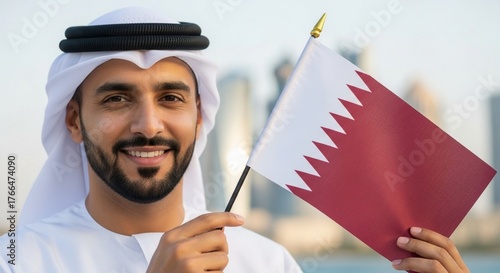 Man in traditional arab clothing holding the qatar flag with city buildings in the background, qatar national day, December 18, QA flag,
