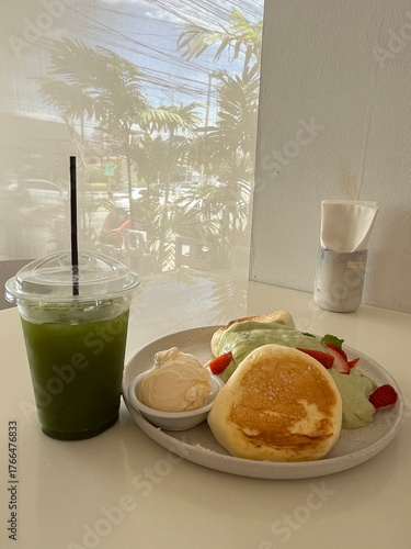 Delicious matcha souffl pancakes with fresh strawberries and green tea 