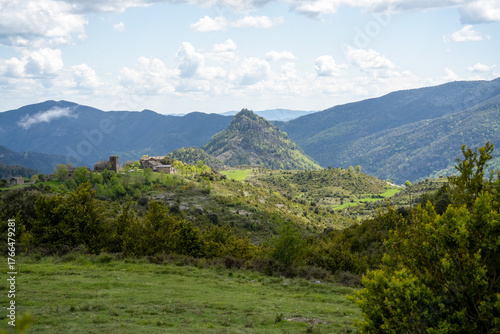 a small village nestled at the foot of a hill in Pyrenees mountains