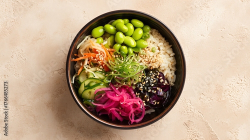 A vibrant and healthy poke bowl filled with fresh vegetables, edamame, rice, and pickled ingredients, served in a dark bowl on a light textured surface.