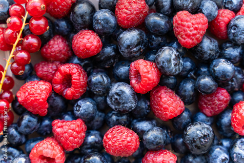 A plate with berries. Blackcurrants, raspberries and blueberries top view.