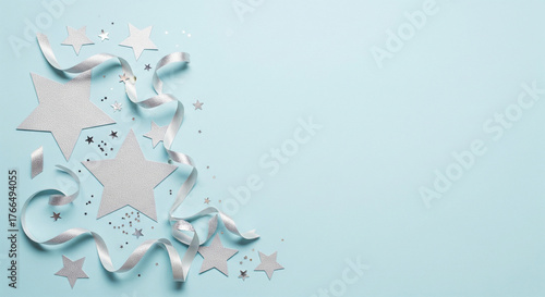 Minimalist blue pastel flatlay New Year background with silver stars and ribbons