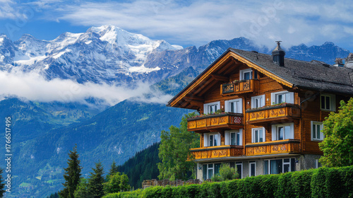 Mountain chalet surrounded by lush greenery and stunning peaks on a clear day