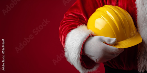 Santa claus wears white gloves and red coat, holding a yellow hard hat. Concept of holiday construction, safety, or charity copy space christmas
