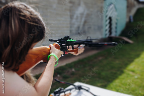 Crossbow shooting and archery at the shooting range, women and men practicing with arbalest at shooting gallery, compound bow training, aiming the target with arbalest at archery range, bow and arrows