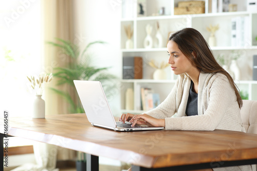 Woman using a laptop on a table at home