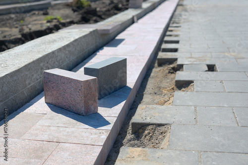 View of paving slabs lying on block paving. Gray rectangular slabs ready for installation.
