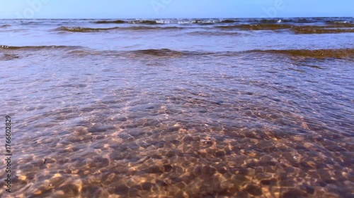 Gentle sea waves rolling over pebbles