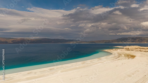 Fotografie The combination of Lake Salda's pure white shallows and deep blue waters with the dramatic cloudy mountain landscape