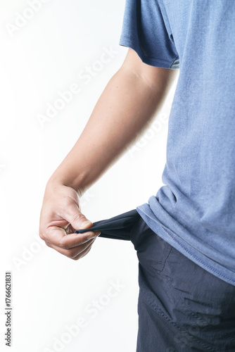 Man sadly pulls out empty pocket showing financial trouble and economic hardship during recession times