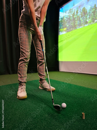 Indoor golfing practice session with a virtual simulator on a green