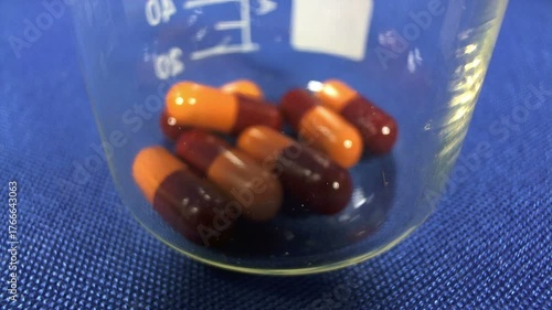 Pillole salvavita che cadono in un becher