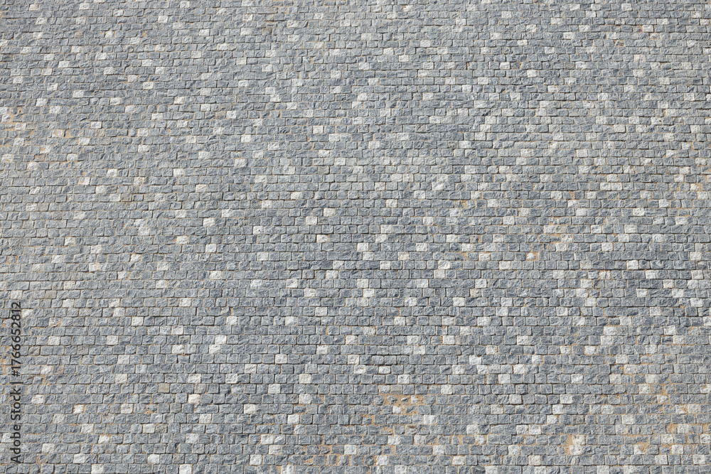 Fototapeta premium Textured gray cobblestone pavement with varying shades and patterns, showcasing the intricate design and craftsmanship of stonework in an outdoor setting